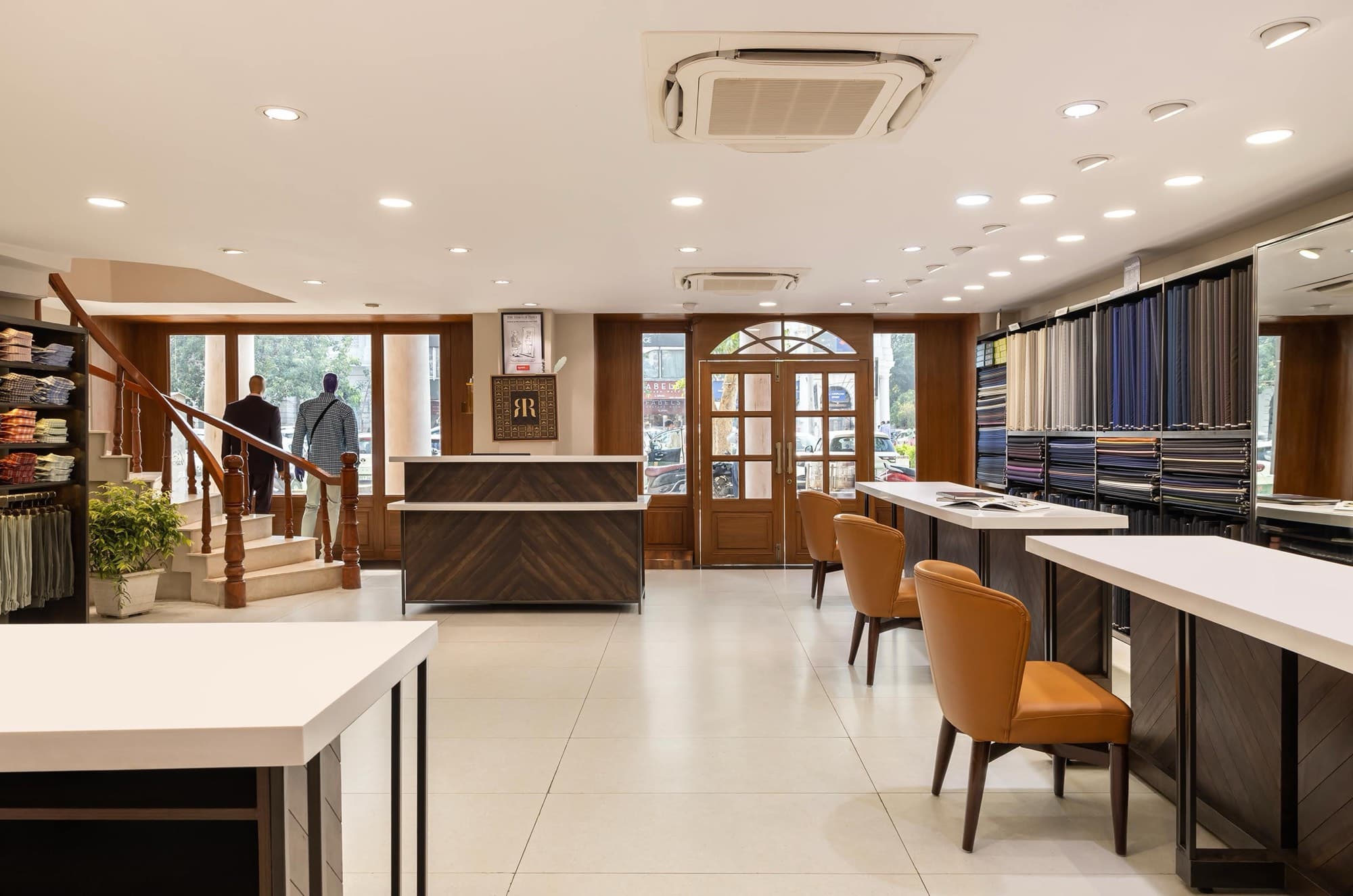 Raymond store interior with tailoring counters, leather chairs and a timber staircase